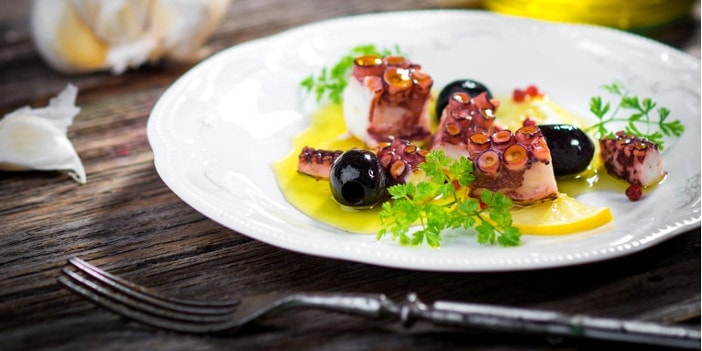 Oktopussalat griechisch mit hochwertigem Olivenöl und schwarzen Oliven